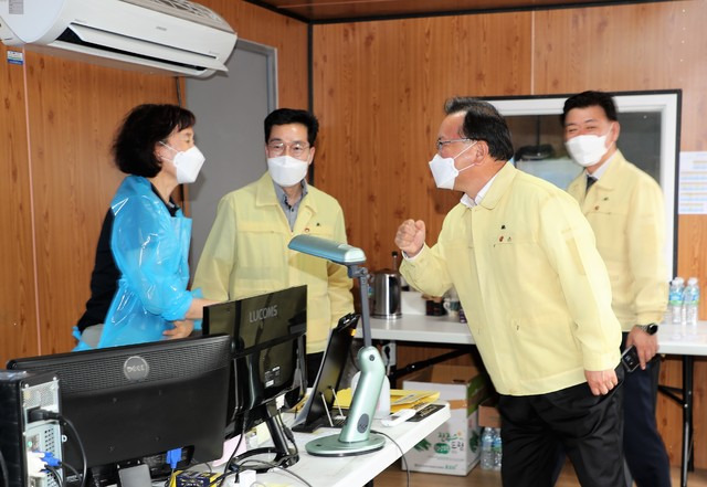 김부겸 총리가 25일 제주공항 워크스루 선별진료소를 방문하고 한 관계자와 '주먹 악수'를 하고 있다. *재판매 및 DB 금지