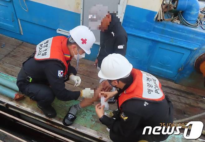목포해경이 갑판 작업 중 부상을 입은 선원을 응급처치하고 있다.(목포해양경찰 제공)2021.6.26/뉴스1 © News1