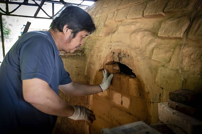 가마에 불을 넣기 전에 입구를 막고 있다.