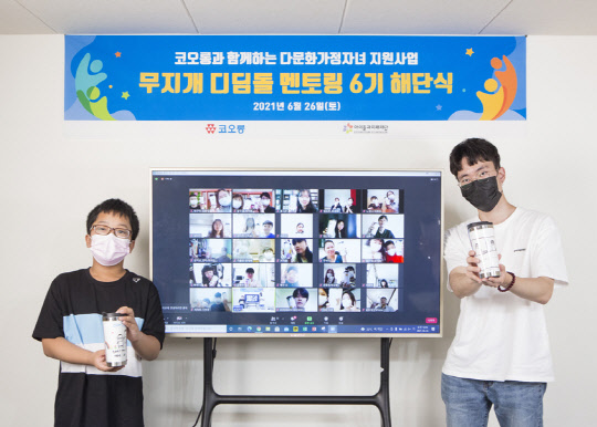 지난 26일 진행된 코오롱그룹 무지개 디딤돌 멘토링 6기 온라인 해단식에 참여한 멘토(오른쪽)와 멘티가 서로에게 전달하는 감사의 메시지가 담긴 텀블러를 들고 기념사진을 찍고 있다. <코오롱 제공>