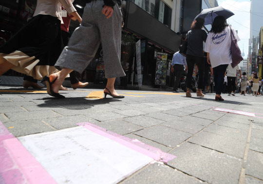지난 21일 서울 명동의 한 음식점 앞 길에 거리두기를 당부하는 안내문이 붙어 있다. 연합뉴스