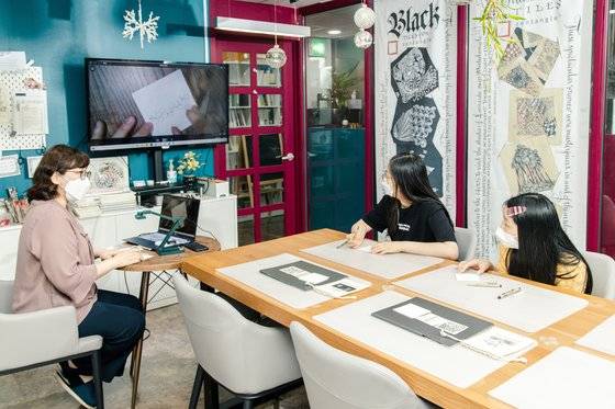 서울 강남구에 있는 아티젠 탱글링캠퍼스를 찾은 소중 학생기자단이 박현주(왼쪽) 공인젠탱글교사의 설명을 들으며 젠탱글을 그리고 있다.