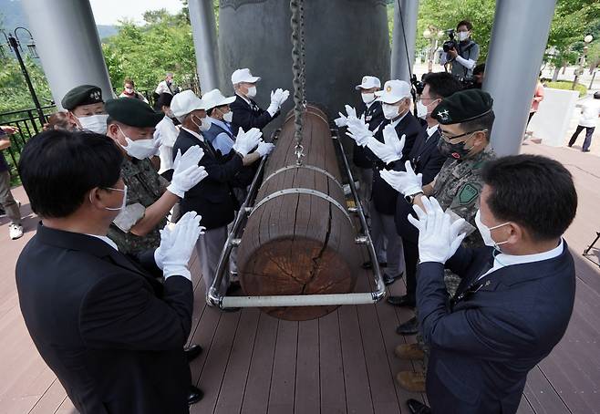 Participants in a ceremony to mark the 71st anniversary of the Korean War strike a bell in Hwacheon County, Gangwon Province, Friday. Penta Press