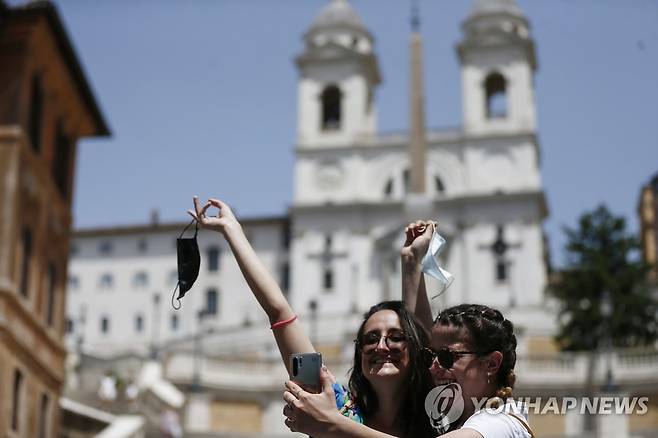 이탈리아에서 옥외 마스크 착용 의무가 해제된 28일(현지시간) 로마 스페인 광장에서 관광객 2명이 마스크를 벗고 셀카를 찍고 있다. [AP=연합뉴스]
