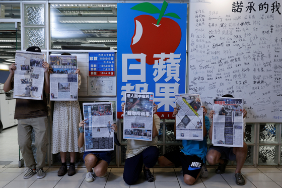 Staff members of Apple Daily and its publisher Next Digital pose with the final edition of the newspaper at its headquarters in Hong Kong on June 24.