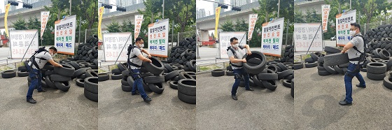 기자가 웨어러블 로봇 '스텝업'을 착용하고 타이어를 옮기는 작업을 하는 모습/사진=류준영