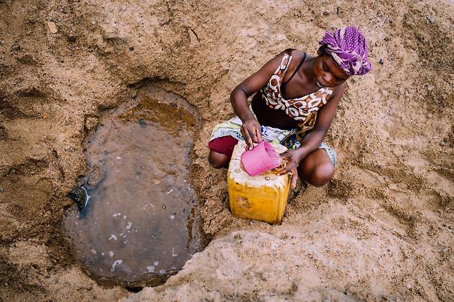 기후변화로 인한 극심한 가뭄으로 고통받고 있는 마다가스카르의 한 여성이 먼 길을 걸어 물을 담고 있다 로이터 연합뉴스