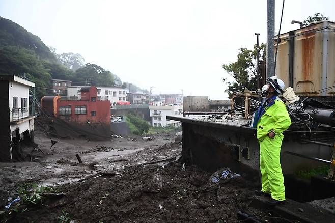 한 소방구조대 요원이 4일 아침 산사태 현장에서 피해 상황을 둘러보고 있다. AFP=연합뉴스