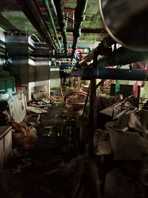 수거될 날을 기다리는 지하실 쓰레기들. 바닥에는 오물이 뒤섞인 침출수가 가득하다.