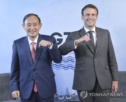 지난 6월 영국 콘월에서 열린 주요 7개국(G7) 정상회의에서 만나 팔꿈치 인사를 나누는 스가 요시히데 일본 총리(왼쪽)와 에마뉘엘 마크롱 프랑스 대통령. [교도=연합뉴스 자료사진]