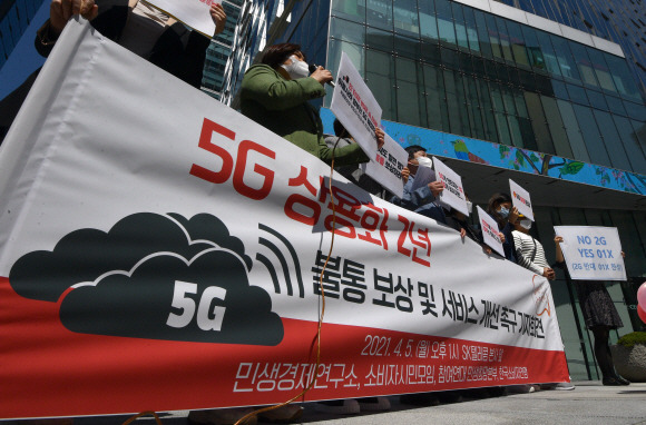 5일 서울 sk텔레콤 본사앞에서 열린 5G 불통 보상 및 서비스 개선 촉구 기자회견에 참석한 민생경제연구소 소속 회원들이 피켓을 들고 있다.  2021.4.5 박지환기자 popocar@seoul.co.kr