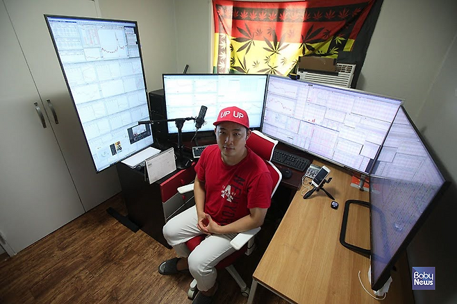 직장인에서 주식 전업투자자가 된 아빠 김광헌 씨가 작은방에 마련한 업무 책상에서 HTS(home trading system) 화면을 배경으로 포즈를 취하고 있다. 최대성 기자 ⓒ베이비뉴스