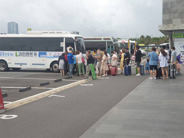 지난 5일 제주국제공항 인근에 위치한 제주공항 렌터카하우스에서 관광객들이 렌터카 셔틀 탑승을 위해 줄지어 차례를 기다리고 있다.  [최현재 기자]