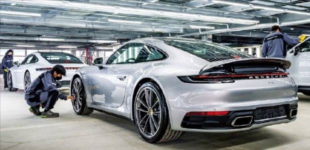 포르쉐가 지난 5월 경기 평택에 새로 문을 연 차량물류센터에서 엔지니어들이 차량을 살펴보고 있다. /포르쉐 제공