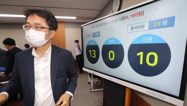 박준식 최저임금위원회 위원장이 12일 밤 제9차 전원회의에서 내년도 최저임금을 9160원으로 의결한 뒤 위원들과 인사하기 위해 이동하고 있다. 연합