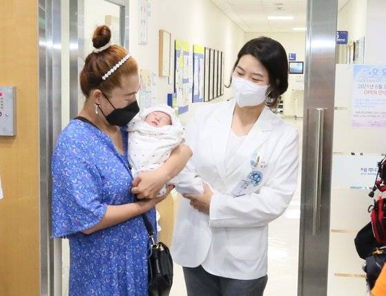 심정지를 극복하고 출산한 아이를 안고 있는 산모 강모(왼쪽)씨와 이번 수술을 집도한 제주대병원 산부인과 김리나 교수. 사진 제주대학교병원