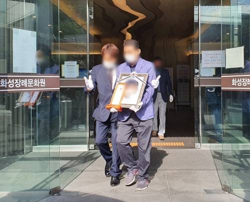 7월14일 양부로부터 모진 학대를 당해 두 달 동안 연명치료를 받아오다 결국 숨을 거둔 두살배기 민영양의 발인식에서 양외조부가 영정을 들고 이동하고 있다. ⓒ 연합뉴스