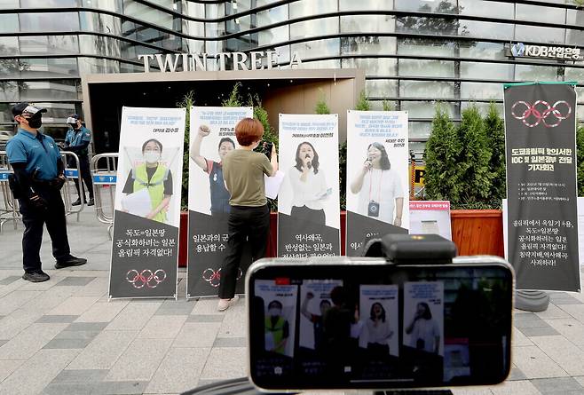 Kwon Soon-young, steering committee chair of the Seoul Kyoreh Hana, moderates the group’s press conference on Thursday in front of the Japanese Embassy in Seoul to condemn the International Olympic Committee and the Japanese government. Kwon is relaying messages from Lee Yeon-hee, the group’s director-general, via telephone. (Lee Jong-keun/The Hnakyoreh)