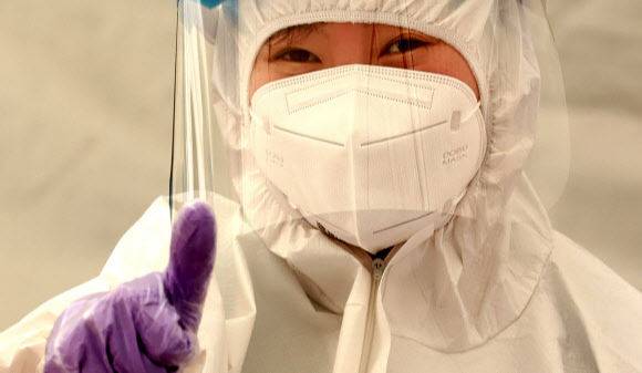 방역당국 관계자가 15일 인천 연수구 원인재역 임시선별검사소에서 취재진을 바라보고 있다. 뉴스1