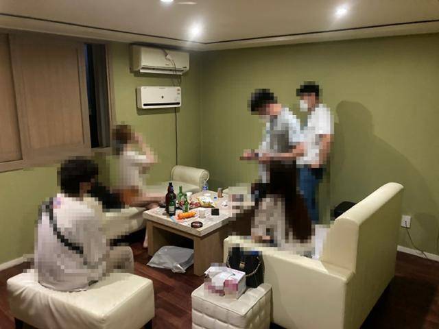 17일 경찰이 급습한 수원시 인계동의 한 모텔 룸. 테이블 위에 술과 안주가 놓였고, 손님과 유흥접객원이 경찰 조사를 받고 있다. 경기남부경찰청 제공