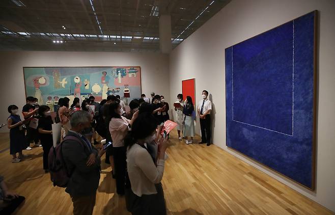Curator Park Mi-hwa explains Kim Whan-ki’s works, “Eco 19-II-73 #307,” “3-X-69 #120,” (right) and “Woman and Jars,” at a press preview of the “MMCA Lee Kun-hee Collection: Masterpieces of Korean Art” at the MMCA Seoul on Tuesday. (Yonhap)