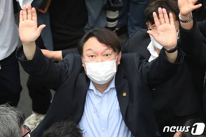 야권 대선주자인 윤석열 전 검찰총장이 20일 낮 대구 서문시장을 찾아 상가 연결통로에 환영 나온 시민들을 향해 손을 흔들어 인사하고 있다. 2021.7.20/뉴스1 © News1 공정식 기자