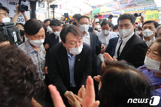 야권 대선주자인 윤석열 전 검찰총장이 20일 낮 대구 서문시장을 찾아 시민들과 인사 나누고 있다. 2021.7.20/뉴스1 © News1 공정식 기자