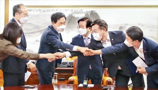 윤호중 더불어민주당 원내대표(왼쪽 다섯 번째), 김기현 국민의힘 원내대표(세 번째) 등 여야 원내지도부가 23일 박병석 국회의장(네 번째) 주재로 국회의장실에서 상임위원장 배분에 합의한 뒤 악수하고 있다.  /뉴스1