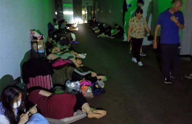 정저우시 수재민들이 호텔 복도에서 휴식을 취하고 있다