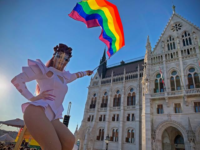 지난 달 14일 헝가리 부다페스트의 의사당 앞에서 열린 성 소수자(LGBT) 권리 시위에서 한 여장 남성이 무지개 깃발을 흔들고 있다. AP 뉴시스