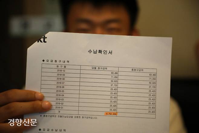 휴대폰 개통 사기 피해를 입은 발달장애인이 통신사로부터 받은 요금청구내역서를 들고 있다.  박민규 선임기자 parkyu@kyunghyang.com