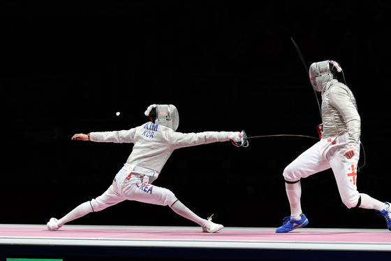 Kim Jung-hwan lunges toward Sandro Bazadze of Georgia in the men’s sabre bronze medal match at Makuhari Messe Hall, Chiba, Japan on Saturday. [JOINT PRESS CORPS]