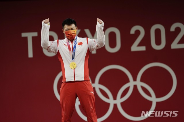 [도쿄=AP/뉴시스]천리쥔(중국)이 25일 2020 도쿄올림픽 역도 남자 67㎏에서 금메달을 따낸 뒤 기뻐하고 있다. 2021.07.25.