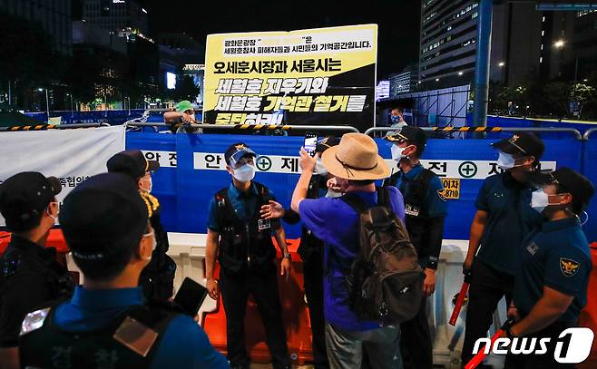 26일 저녁 서울 종로구 광화문 광장에서 한 시민이 마스크를 벗은 채 세월호 기억공간 쪽을 스마트폰으로 촬영하고 있다. 2021.7.26/뉴스1 © News1 안은나 기자