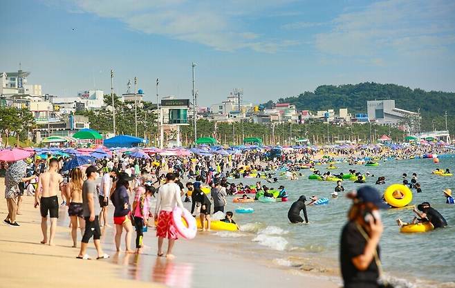 People cool off on Daecheon Beach in Boryeong, South Chungcheong Province, on Sunday. (Yonhap News)