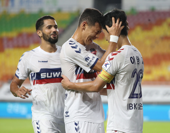 Lee young-jae of Suwon FC, middle, celebrate with his teammates after scoring a winning goal against the Suwon Samsung Bluewings at the Suwon World Cup Stadium in Suwon, Gyeonggi on Tuesday. [ILGAN SPORTS]