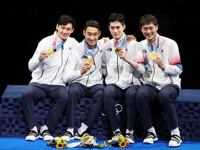 28일 일본 지바의 마쿠하리 메세에서 열린 도쿄올림픽 남자 펜싱 사브르 단체전 결승전에서 이탈리아에 승리해 금메달을 획득한 대한민국 구본길, 김정환, 김준호, 오상욱 선수가 시상대에서 금메달을 보여주며 활짝 웃고 있다. <저작권자(c) 연합뉴스, 무단 전재-재배포 금지>