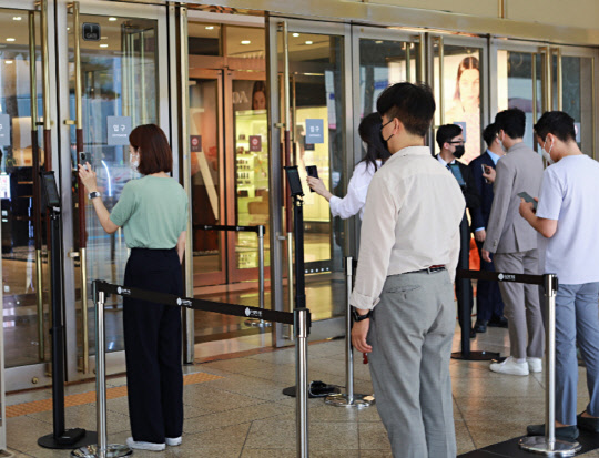지난 28일 서울 소공동 롯데백화점 본점에서 직원들이 QR체크인 시스템을 테스트하고 있다. 롯데백화점 제공