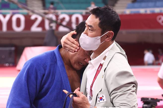 29일 일본 도쿄 무도관에서 열린 도쿄올림픽 유도 남자 100 kg급 결승 경기에서 한국 조구함이 일본 에런 울프에게 패한 뒤 눈물을 흘리자 송대남 코치가 위로하고 있다. [연합뉴스]