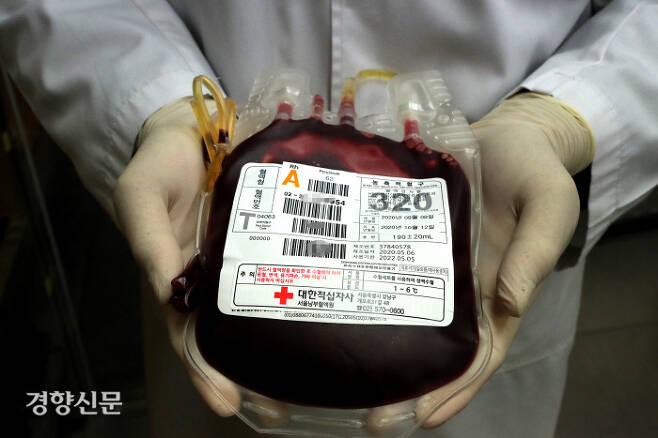 코로나19 사태 등으로 헌혈이 줄어들면서 혈액 부족 상황이 계속되는 가운데 정부가 29일 인공혈액 연구개발 계획을 내놓았다. 사진은 대한적십자사 관계자가 수혈봉투를 들어보이며 시민들의 헌혈 참여를 요청하는 모습이다. 경향신문 자료사진