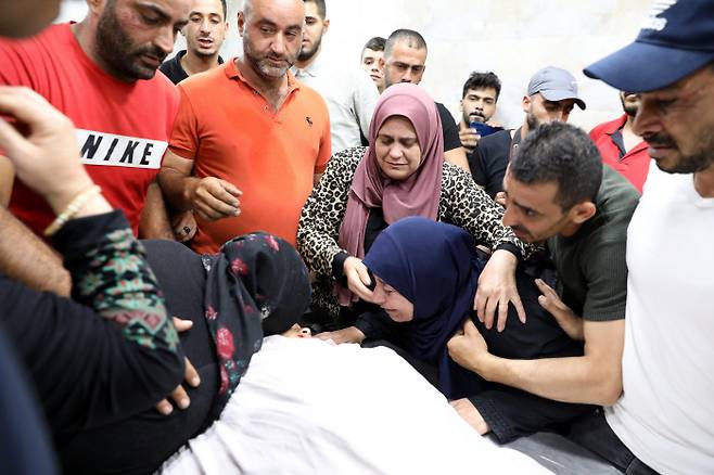 아버지와 함께 집으로 가다 이스라엘군이 쏜 총에 맞아 숨진 12세 팔레스타인 소년의 유족들이 28일(현지시간) 장례식을 치르며 애통해하고 있다. 헤브론 | EPA연합뉴스