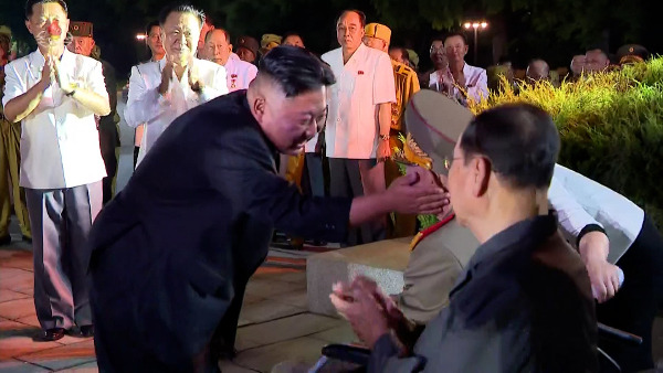 김정은 북한 국무위원장이 6·25전쟁 정전협정 체결 68주년인 지난 27일 평양 조국해방전쟁 승리기념탑 앞에서 열린 제7회 전국노병대회에서 한 노병의 볼을 쓰다듬고 있다. 연합뉴스