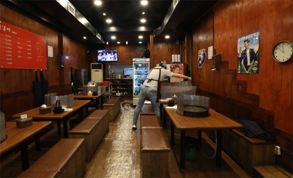 코로나19로 모임이 줄어들면서 음식점업이 타격을 받은 가운데 29일 서울시 종로구 한 식당에서 식당 주인이 테이블을 정리하고 있다. [이충우 기자]