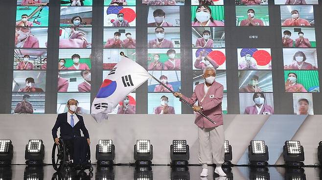 정진완 대한장애인체육회장으로부터 단기를 수여받은 뒤 힘차게 흔드는 주원홍 선수단장