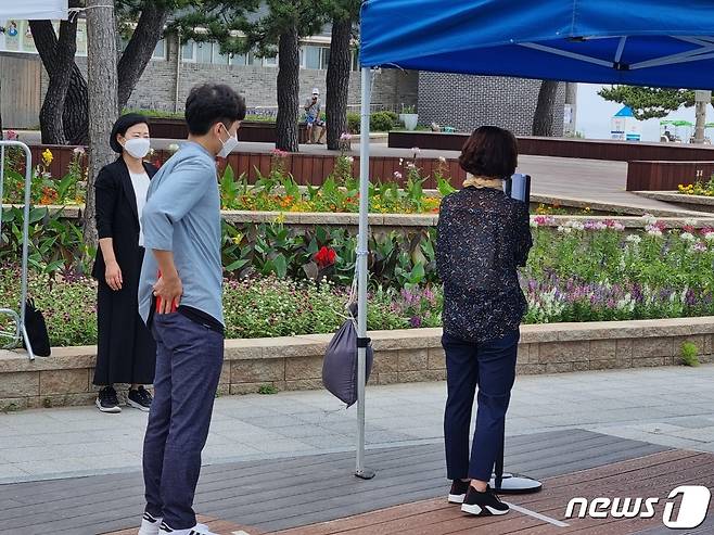 코로나19 4차 대유행이 본격화 되고 있는 가운데 14일 강원 강릉시가 개장을 앞둔 경포해수욕장에서 진행한 방역 시연회에서 입장객들이 발열체크를 위해 대기하고 있다.2021.7.14/뉴스1 © 윤왕근 기자