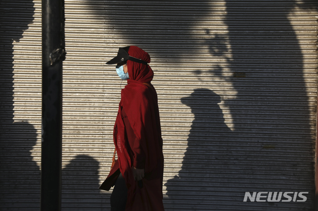 [테헤란(이란)=AP/뉴시스]20일(현지시간) 이란 테헤란 남부에서 마스크를 낀 여성이 걷고 있다. 2021.7.21