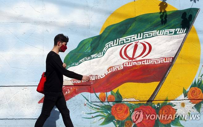 이란 국기 앞을 지나는 테헤란 젊은이 [EPA=연합뉴스 자료사진]