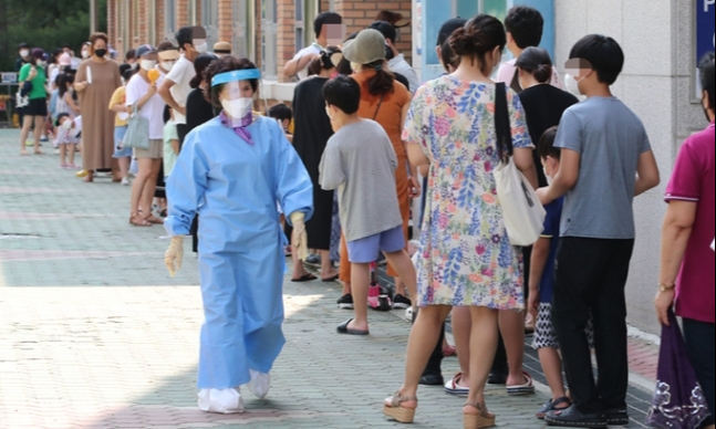 대전 서구 한 초등학교에서 격리해제 예정자 1000여명이 PCR 검사를 받기 위해 기다리고 있다. 뉴스1