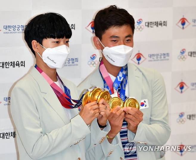[올림픽] 안산·김제덕 '둘이 금메달이 다섯개' (영종도=연합뉴스) 임헌정 기자 = 2020 도쿄올림픽 양궁 대표팀 안산(왼쪽), 김제덕이 1일 오후 영종도 인천국제공항을 통해 귀국한 뒤 금메달을 들어보이고 있다. 2021.8.1 kane@yna.co.kr