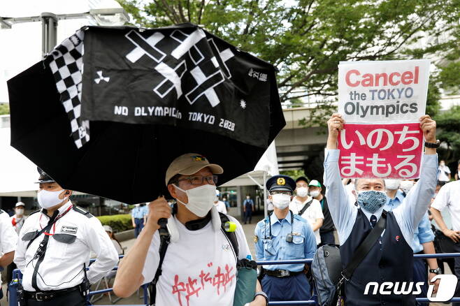 지난 7월23일(현지시간) 도쿄 올림픽 개최에 반대하는 시위대가 도쿄 도청 앞에서 '올림픽 취소하라'라고 써진 팻말을 들고 있는 모습. © 로이터=뉴스1 © News1 이정후 기자